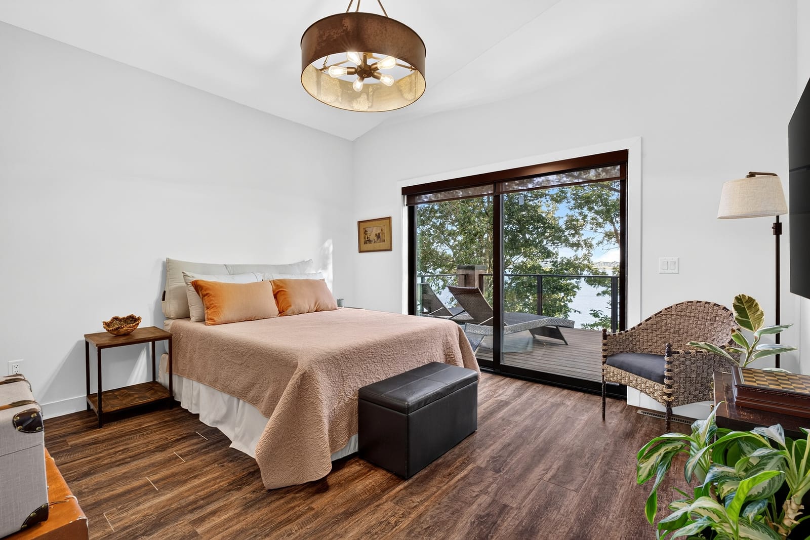 The first primary suite, with the lake visible through the glass.